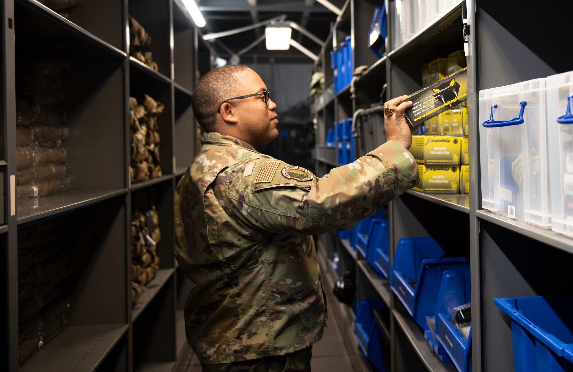 Tech. Sgt. Rashan Taggart, 48th Security Forces Squadron supply warehouse noncommissioned officer in charge, places boxes of latex gloves on a shelf at Royal Air Force Lakenheath, England, April 16, 2020. With an increased need for personal protective equipment and sanitizing products, monitoring supply and demand are crucial to ensure that squadron Airmen have critical items required to safely execute the mission. (U.S. Air Force photo by Airman 1st Class Jessi Monte)