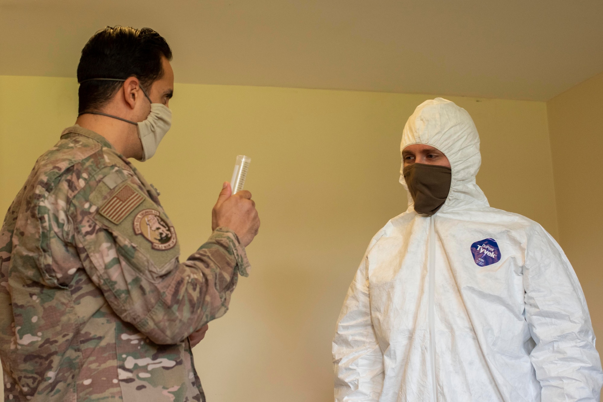 Tech. Sgt. Matthew Borquez, 100th Civil Engineer Squadron emergency management logistics noncommissioned officer in charge, instructs a Team Mildenhall Airman on the proper amount of household bleach needed to create a cleaning solution at RAF Mildenhall, England, April 15, 2020. Cleaning-team members use chemicals that would destroy any potential Coronavirus remaining on common surfaces. (U.S. Air Force photo by Airman 1st Class Joseph Barron)