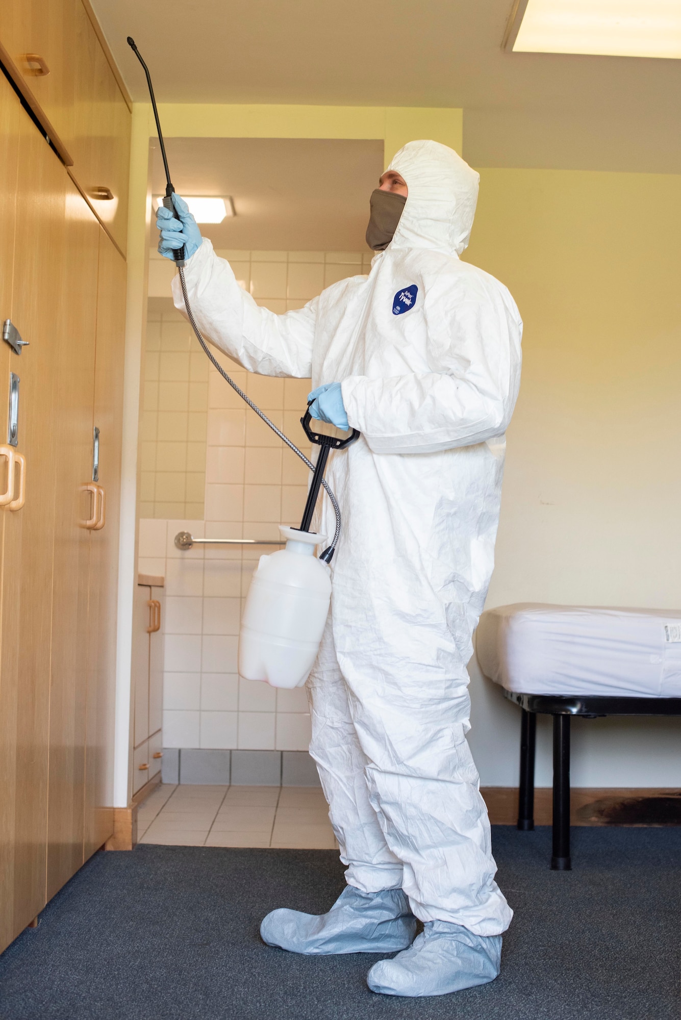 A Team Mildenhall Airman simulates spraying a bleach solution as part of his cleaning-team training at RAF Mildenhall, England, April 15, 2020. The base cleaning team is a precautionary force established to fight the spread of COVID-19 and protect the health and wellness of Airmen. (U.S. Air Force photo by Airman 1st Class Joseph Barron)