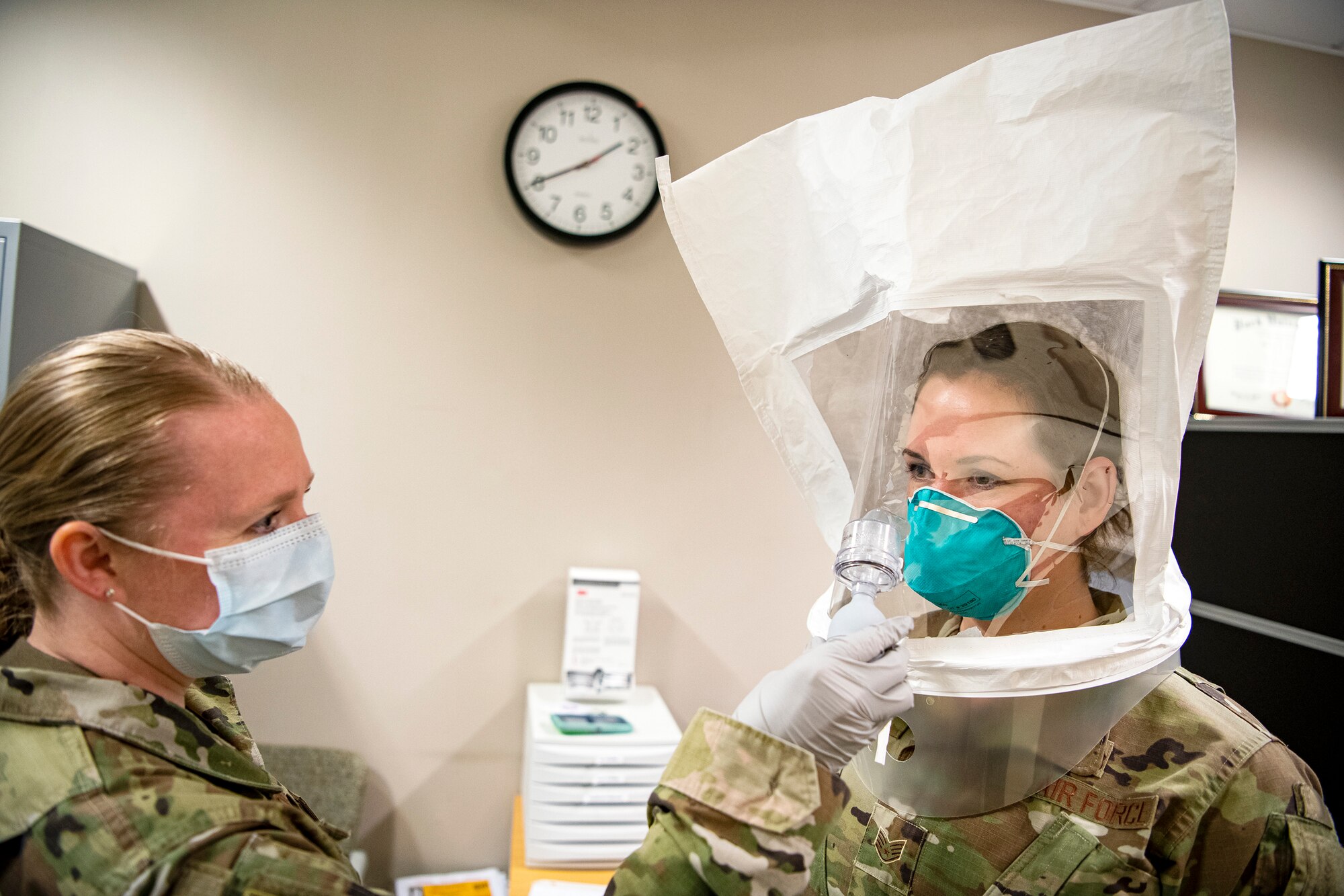 U.S. Air Force Tech Sgt. Kristen Nickerson, left, 423d Medical Squadron NCO in charge of bio-environmental engineering, conducts a qualitative fit test on a N95 mask for Staff Sgt. Jennalyse Adam, 423d MDS dental assistant, at RAF Alconbury, England April 14, 2020. The 423d MDS were conducting fit tests of the N95 mask to ensure personnel are safe to continue to treat patients who may have contracted the novel coronavirus. (U.S. Air Force photo by Senior Airman Eugene Oliver)