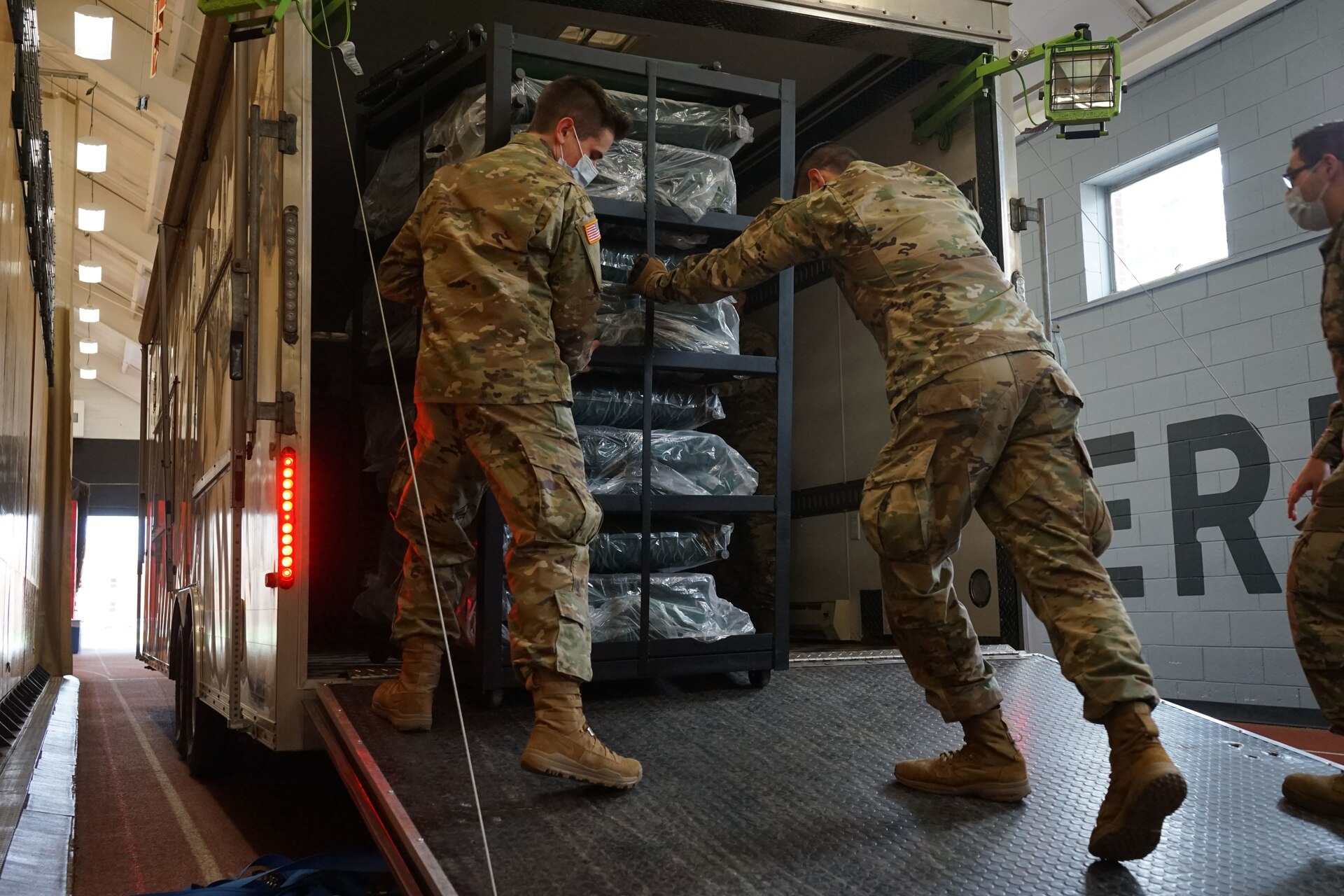 Soldiers from the Pennsylvania National Guard help unload supplies from a Pennsylvania Department of Health trailer at East Stroudsburg University's Koehler Fieldhouse on April 14, 2020.