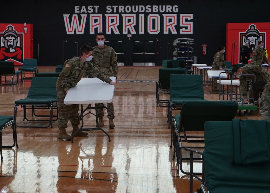 Pennsylvania National Guard Soldiers support officials from the Pennsylvania Department of Health and PA Emergency Management Agency to establish an alternate care site at East Stroudsburg University on April 14, 2020. The combined group set up more than 64 cots, with additional cots available if the need arises.