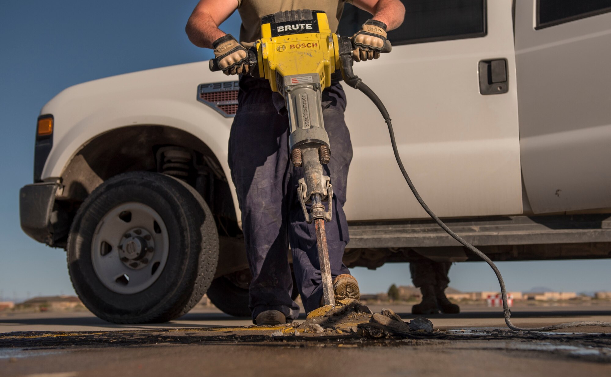 Staff Sgt. Michael Carico, 49th Civil Engineer Squadron pavements and construction equipment operator, breaks up a defected area of the flight line with a jack hammer on Holloman Air Force Base, N.M., April 11, 2020. The pavements and construction Airmen replaced a break in the concrete to prevent any safety hazards from occurring during future flightline operations. (U.S. Air Force photo by Staff Sgt. Christine Groening)