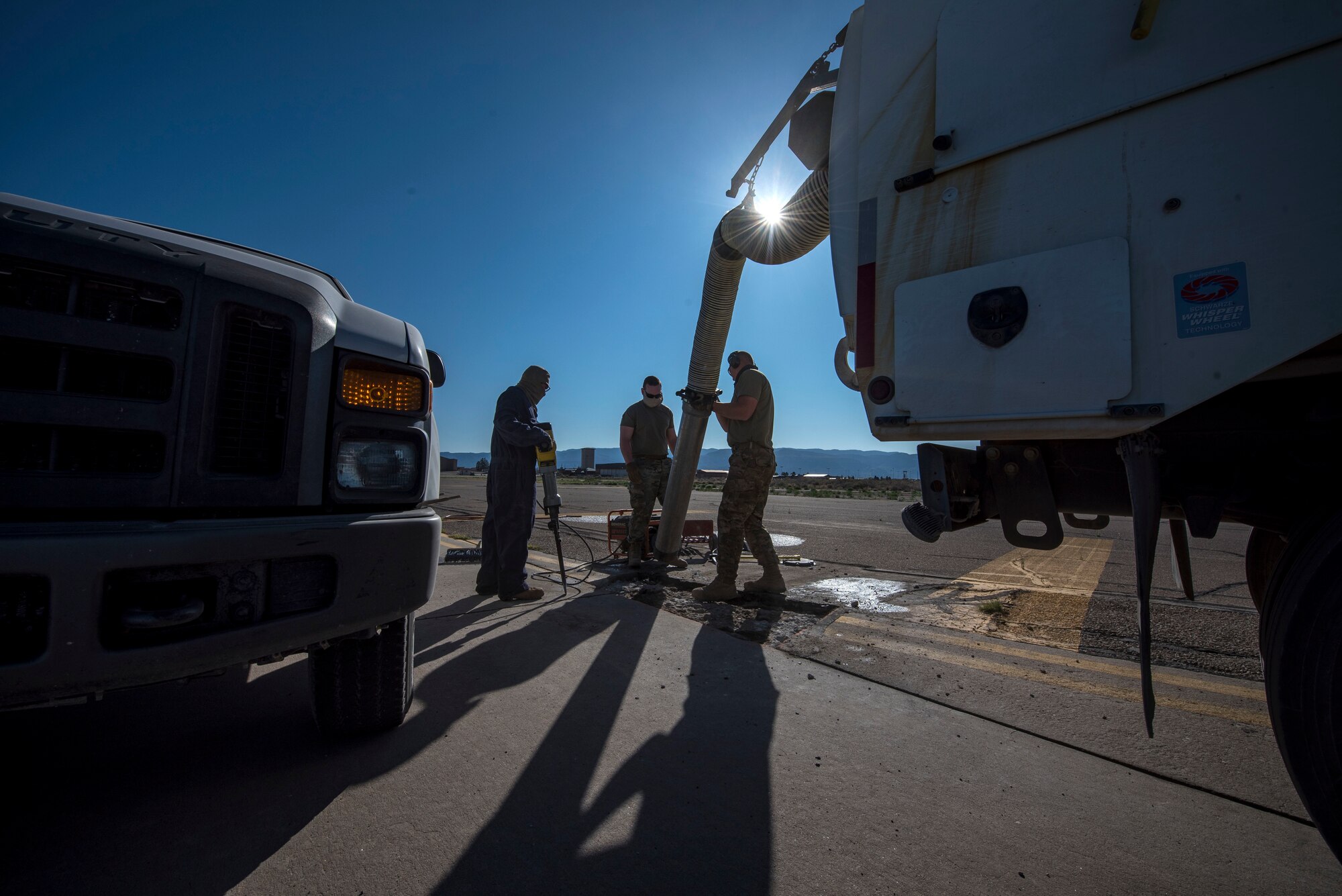 Airmen from the 49th Civil Engineer Squadron pavements and construction equipment shop clean up concrete debris with a sweeper truck on the flightine on Holloman Air Force Base, N.M., April 11, 2020. The shop is responsible for keeping the airfields clean, smooth and safe for flight operations. (U.S. Air Force photo by Staff Sgt. Christine Groening)