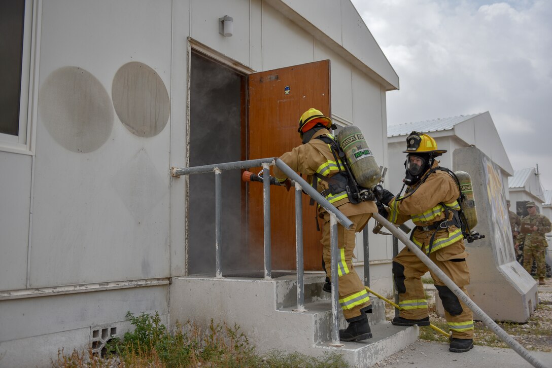 Firefighters assigned to the 379th Expeditionary Civil Engineer Squadron enter a building during a theater ballistic missile exercise at Al Udeid Air Base, Qatar on April 16, 2020. The 379th Air Expeditionary Wing regularly conducts exercises at AUAB to maintain readiness in a deployed environment. This enables the base to sustain air power across the U.S. Central Command area of responsibility.