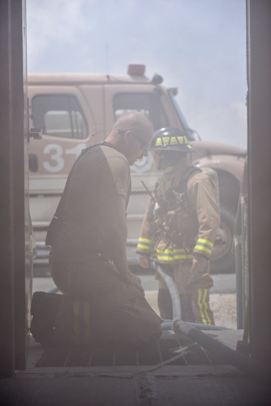 Firefighters assigned to the 379th Expeditionary Civil Engineer Squadron pull a fire hose through a building during a theater ballistic missile exercise at Al Udeid Air Base, Qatar on April 16, 2020. The 379th Air Expeditionary Wing regularly conducts exercises at AUAB to maintain readiness in a deployed environment. This enables the base to sustain air power across the U.S. Central Command area of responsibility.