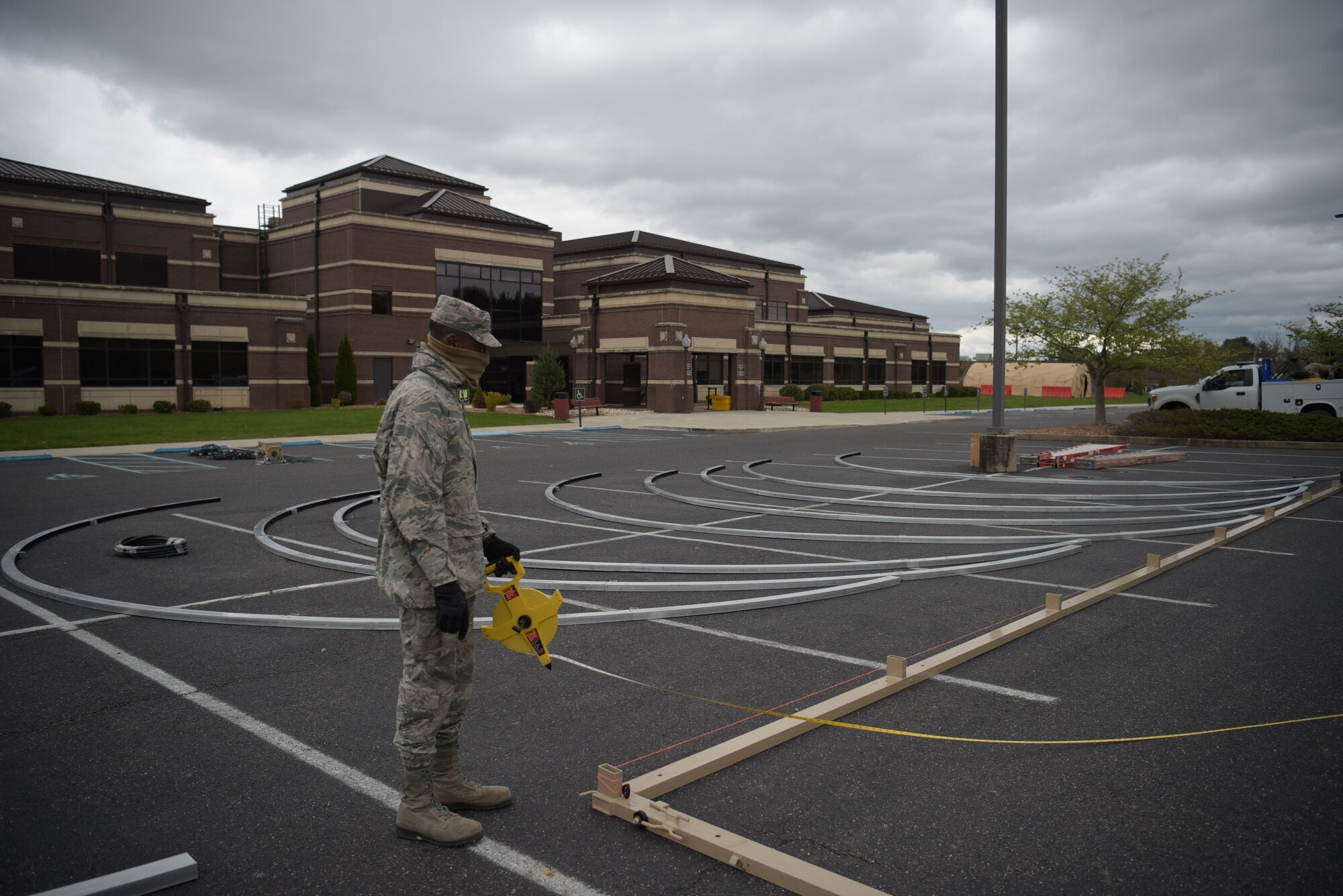 Photo of an Airmen measuring the length for a tent.