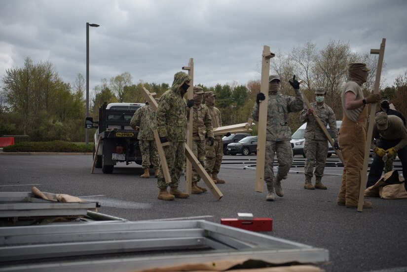 Photo of military members setting up a tent.