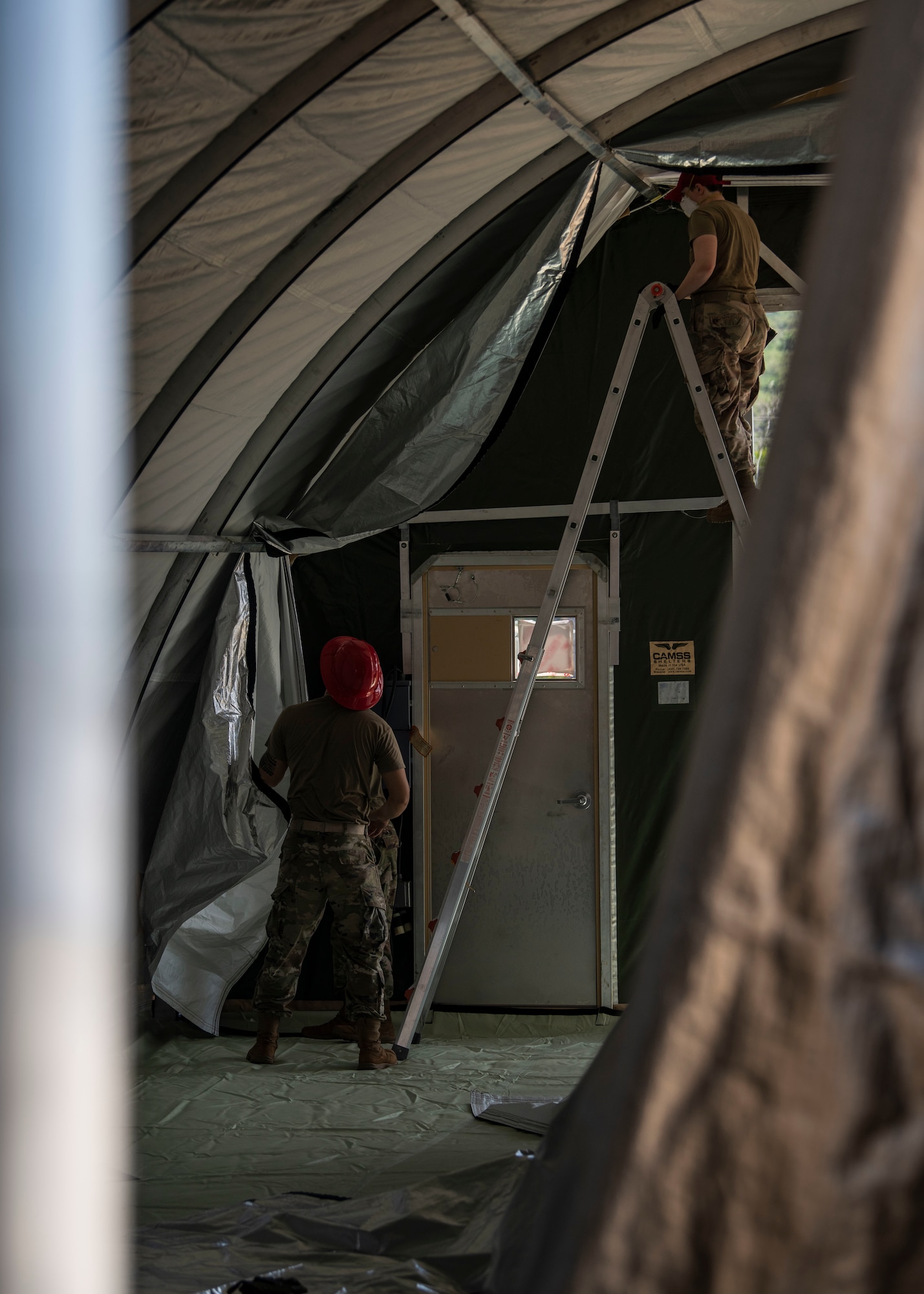 Airmen from the 554th RED HORSE Squadron assemble a temporary warehouse unit as part of the construction of an Expeditionary Medical Support System facility April 13, 2020, at U.S. Naval Hospital Guam.
