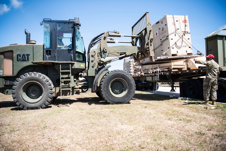 Airmen from the 554th RED HORSE Squadron unload medical supplies for the Expeditionary Medical Support System facility April 13, 2020, at U.S. Naval Hospital Guam.