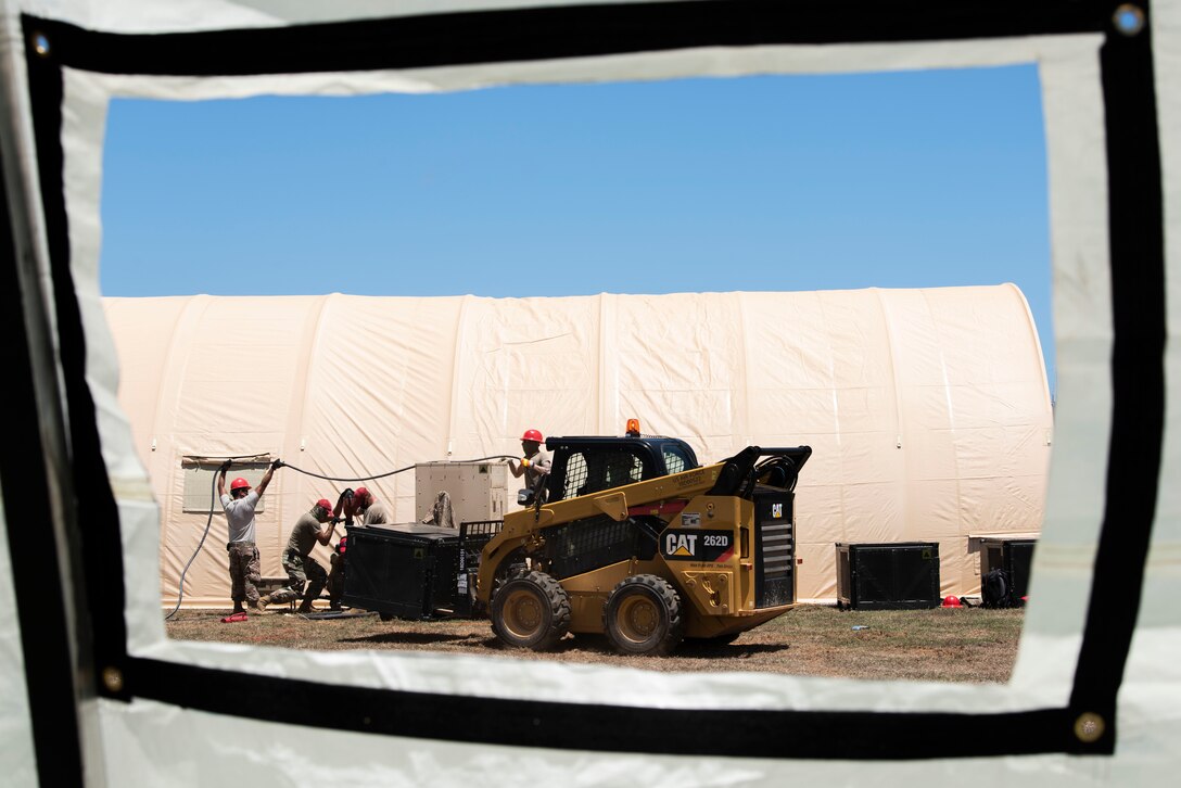 Airmen from the 554th RED HORSE Squadron assemble a temporary warehouse unit as part of the construction of an Expeditionary Medical Support System facility April 13, 2020, at U.S. Naval Hospital Guam.
