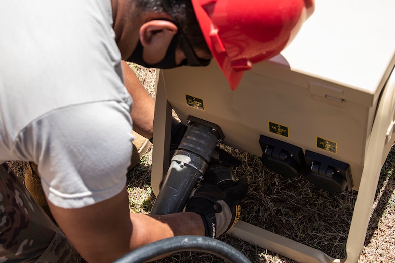 An Airman from the 554th RED HORSE Squadron readies a generator for a temporary warehouse unit as part of the construction of an Expeditionary Medical Support System facility April 13, 2020, at U.S. Naval Hospital Guam.