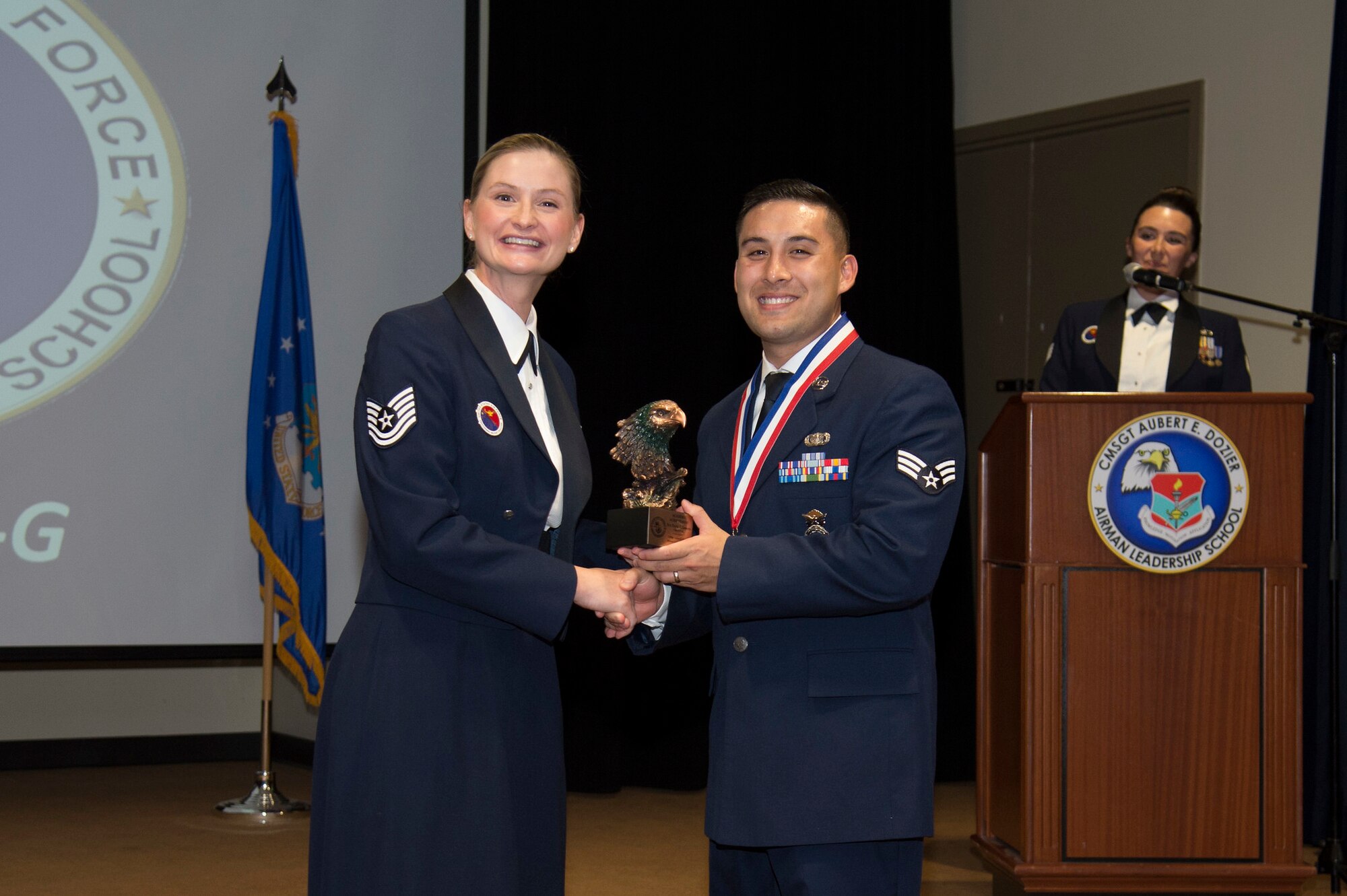 U.S. Air Force Tech. Sgt. Shawna Wise, a 6th Force Support Squadron Airman Leadership School (ALS) instructor, presents the Academic Achievement Award to Staff Sgt. Travis Somera, a 6th Security Forces Squadron entry controller, during an ALS graduation ceremony, Oct. 17, 2019, at MacDill Air Force Base, Fla.