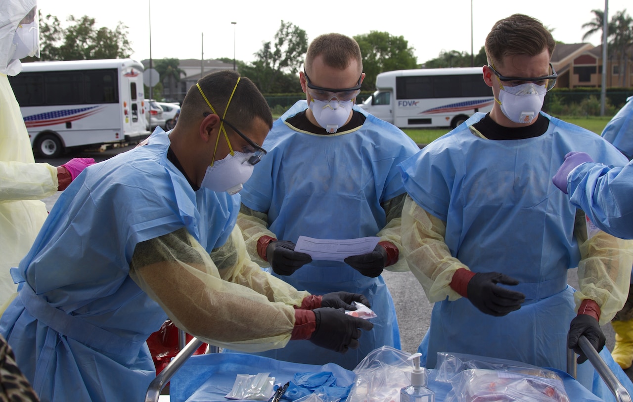 Soldiers wearing protective gear conduct a COVID-19 test.