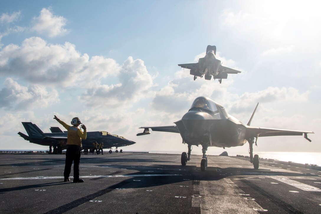 A military aircraft lands on a ship.