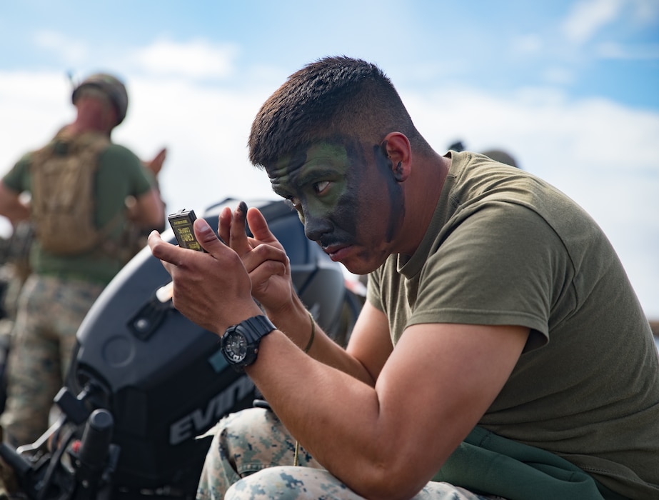 U.S. Marine Corps Lance Cpl. Paul Sobero, a coxswain with Company F, 2nd Battalion, 4th Marine Regiment, 1st Marine Division, applies camouflage paint before a night boat raid on Marine Corps Base Camp Pendleton, California, March 19, 2020. The Marines of Company F conducted boat raids during both day and night for their culminating exercise in preparation for deployment. (U.S. Marine Corps photo by Lance Cpl. Benjamin Aulick)