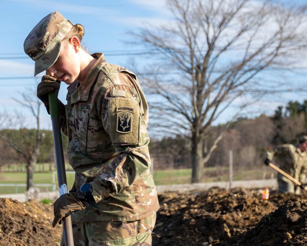 Pfc. Caleigh McLain, an infantry soldier with C Company, 3rd of the 172nd Infantry Regiment (Mountain), and resident of Amherst, digs soil beds in Manchester at the New Hampshire Food Bank garden.