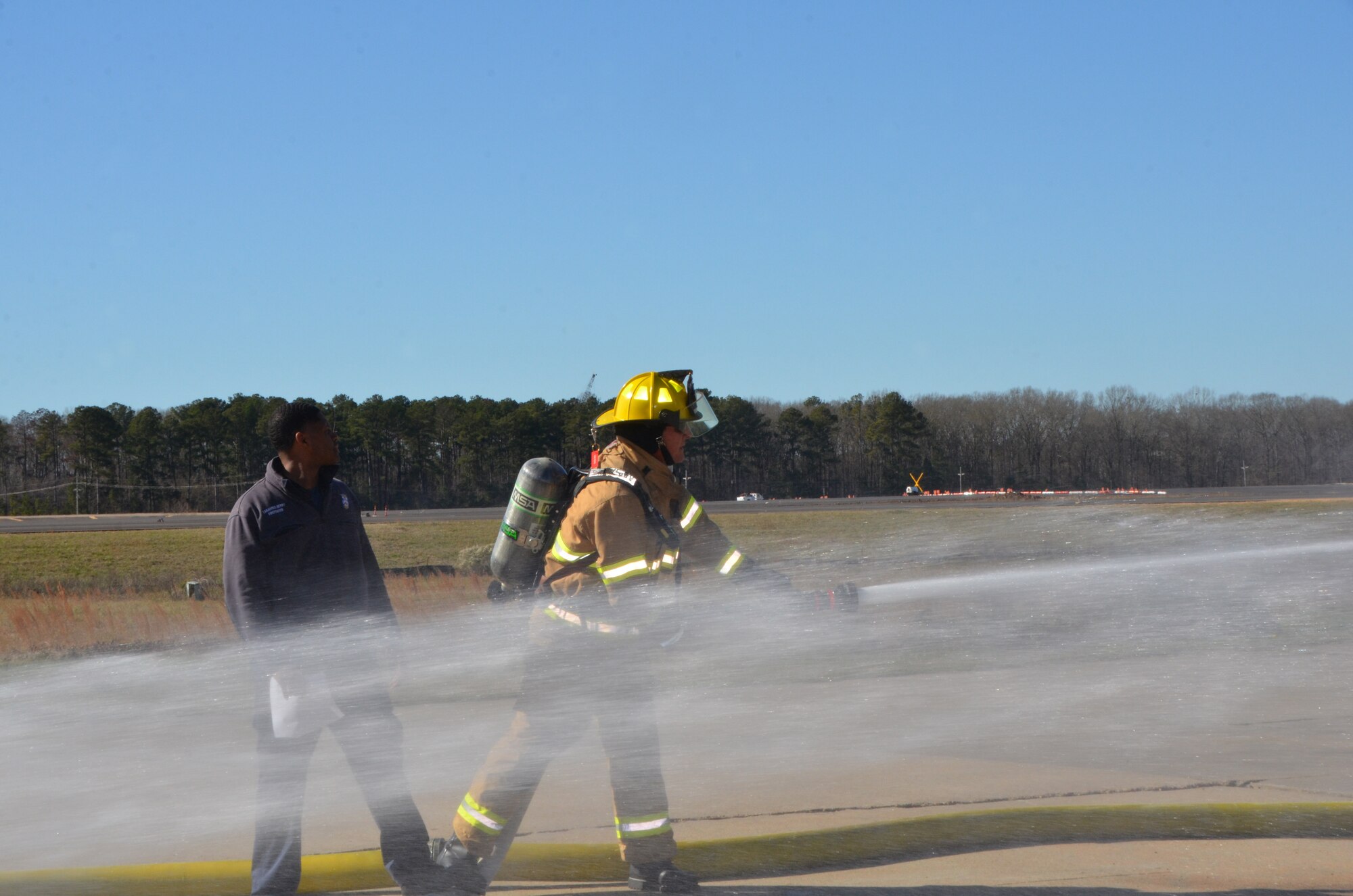 Lineman Robert Walters mans the back-up line as fellow firefighter Tabarious Berry observes his performance.  The crew is running a “Forward Lead-out” Drill. (Air National Guard photo by Master Sgt. Betsy J. Winstead/Released)