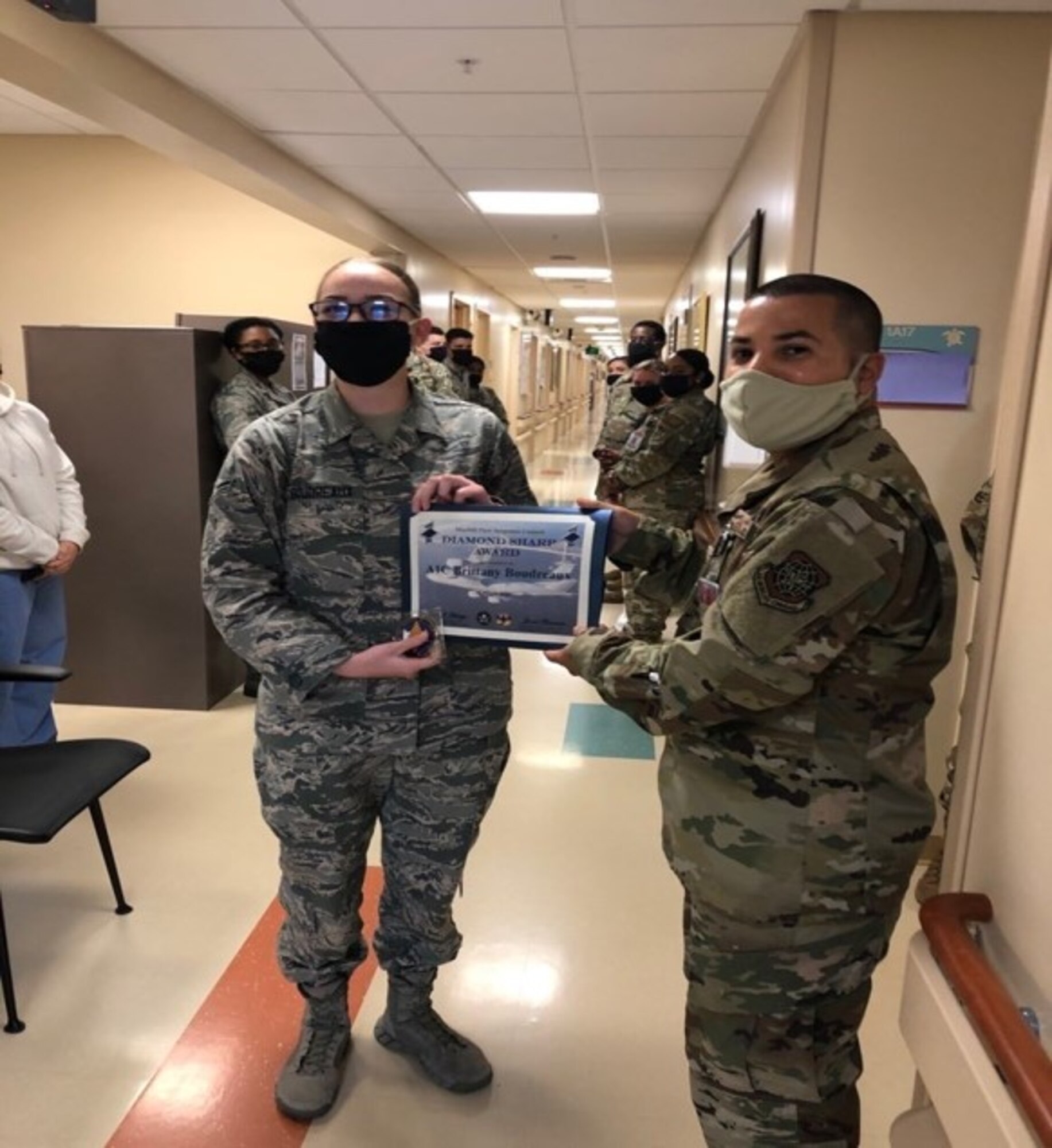 Senior Master Sgt. Jason Olivencia, right, 6th Medical Group first sergeant, presents Airman First Class Brittany Boudreaux, 6th Health Care Operations Squadron medical technician, with the MacDill First Sergeant Council's Diamond Sharp Award for March, 2020. Boudreaux streamlined the patient booking, laboratory order and specimen labeling administrative process, ensuring the effective processing of laboratory specimen, flu and STREP tests, solidifying the medical group’s efforts to protect more than 241,000 beneficiaries and 600 staff members. The Diamond Sharp Award is a monthly award that recognizes an Airman and a non-commissioned officer who excel in the performance of their primary duties, leadership and professionalism. (U.S. Air Force photo)