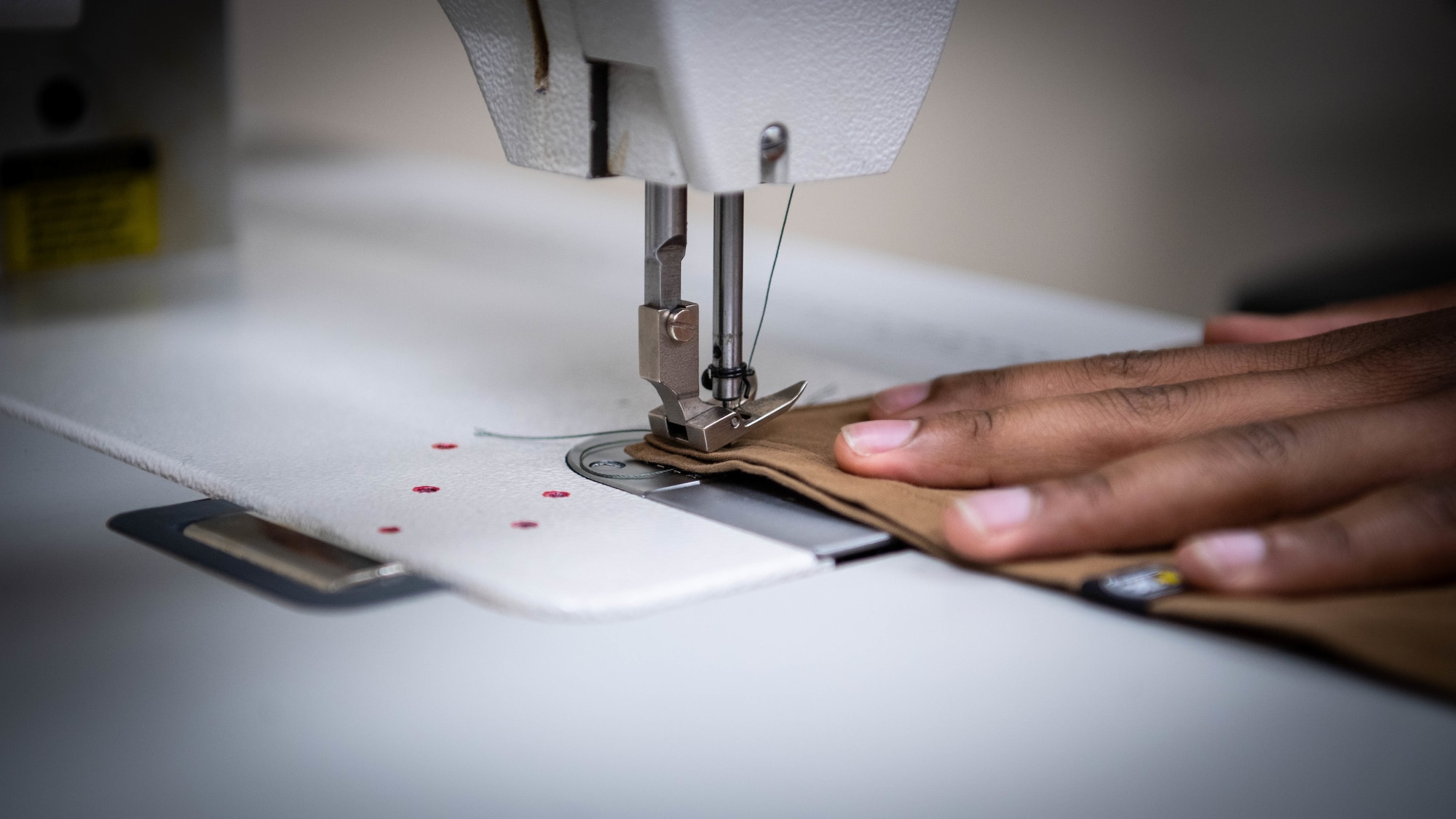 Airman 1st Class David S. Kyambadde, 2nd Operations Support Squadron aircrew flight equipment maintainer, operates a sewing machine to sew masks at Barksdale Air Force Base, La., April 16, 2020. As Barksdale’s health protection measures increased in response to COVID-19, face masks are now required to be worn inside the base exchange, commissary and other base facilities. (U.S. Air Force photo by Airman 1st Class Jacob B. Wrightsman)