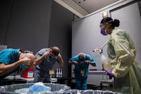 Navy Hospital Corpsman 3rd Class Katie Perez, assigned to Expeditionary Medical Facility Bethesda, Md., leads medical providers in removing their N95 masks in the personal protective equipment doffing station at Javits New York Medical Station, April 13, 2020.