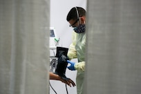 Army Staff Sgt. Jacob Underwood, with the 531st Hospital Center, checks a patient’s vital signs in the medical bay at Javits New York Medical Station, April 16, 2020.
