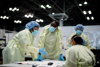 Army Lt. Col. Leslie Curtis-Glanton, a chief nursing officer assigned to the 9th Hospital Center, meets with nursing station staff in the Javits New York Medical Station patient care area, April 17, 2020.