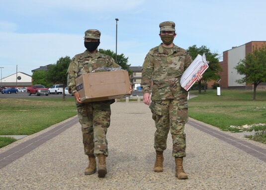 U.S. Air Force Airman 1st Class Nigella Padayao Mina, 316th Training Squadron student, and Airman Carlyn Wagner, 316th TRS student, carry mail while fighting the spread of COVID-19 by wearing masks on Goodfellow Air Force Base, Texas, April 20, 2020. Goodfellow followed the Department of Defense’s guidance, which allowed military members to wear cloth face masks in uniform. (U.S. Air Force photo by Airman 1st Class Abbey Rieves)