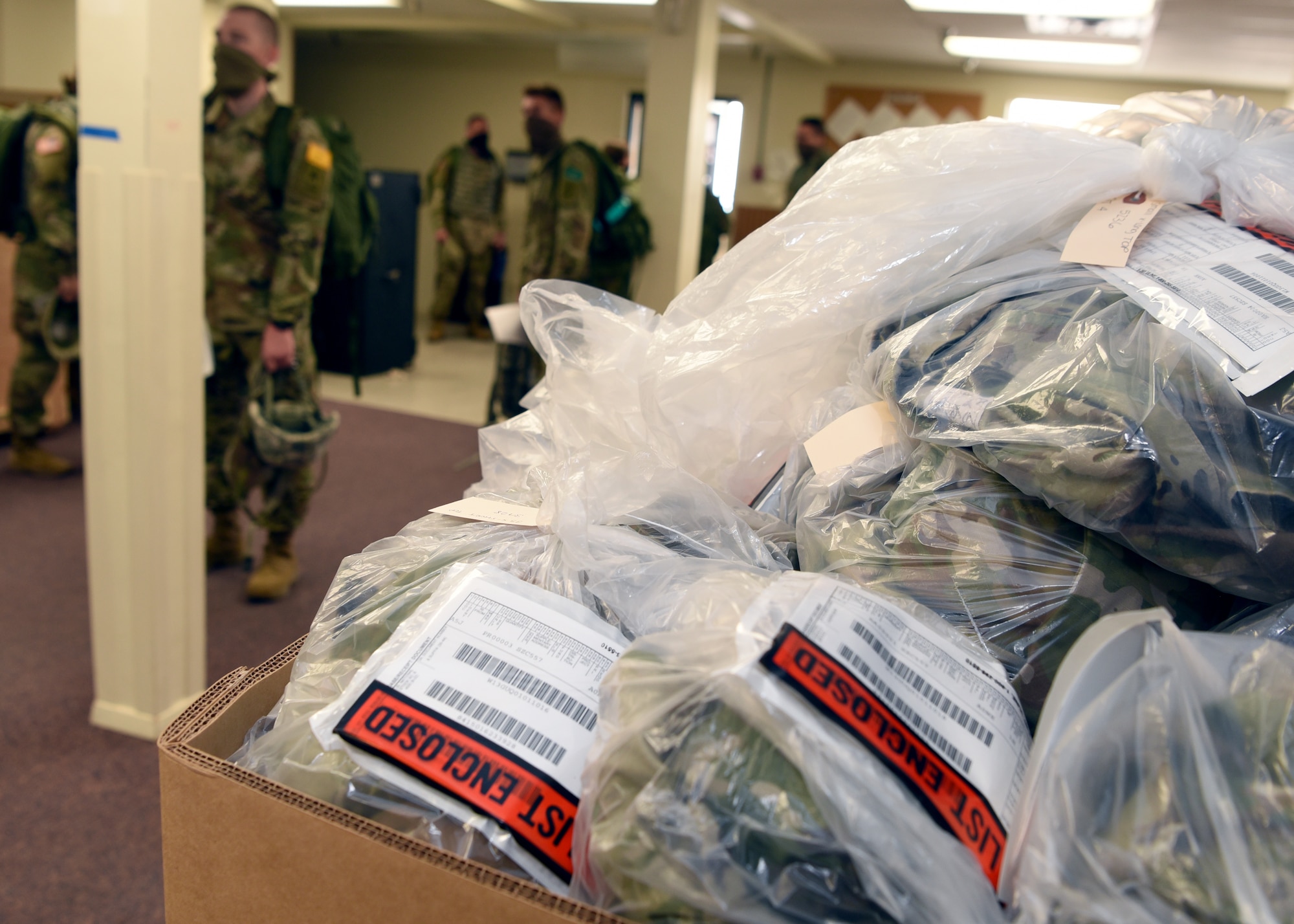 A bin of U.S. Army field exercise equipment is wrapped in plastic for organization and sanitation measures in the 344th Military Intelligence Battalion Supply building on Goodfellow Air Force Base, Texas, April 20, 2020. The Soldiers practiced COVID-19 preventative measures through social distancing and wearing masks, while maintaining mission essential operations. (U.S. Air Force photo by Airman 1st Class Abbey Rieves)