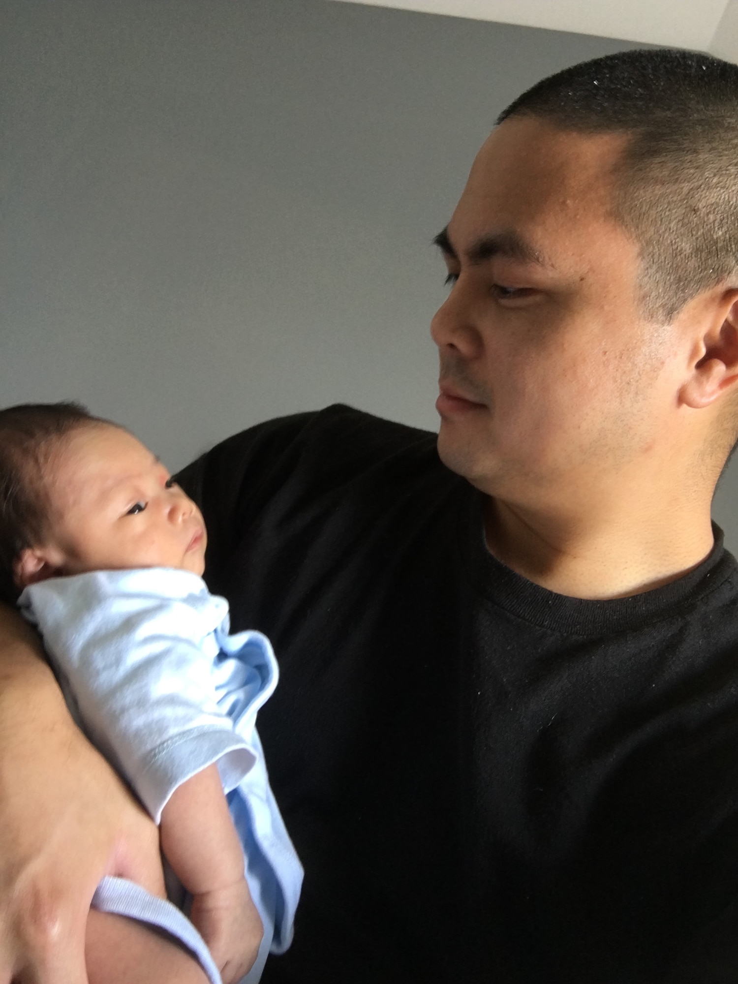 Master Sgt. Matthew Alejandro, 844th Communications Squadron executive team member, holds his newborn, Sean, after emerging from quarantine. Undated photo. (U.S. Air Force photo/ Master Sgt. Matthew Alejandro)