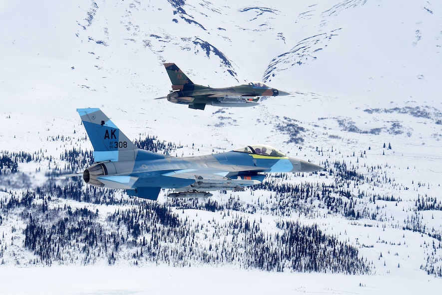 Two U.S. Air Force F-16 Fighting Falcons assigned to the 18th Aggressor Squadron fly over the Joint Pacific Alaska Range Complex during a training sortie with F-22 Raptors stationed at Joint Base Elmendorf-Richardson in Anchorage, Alaska, April 17, 2020.