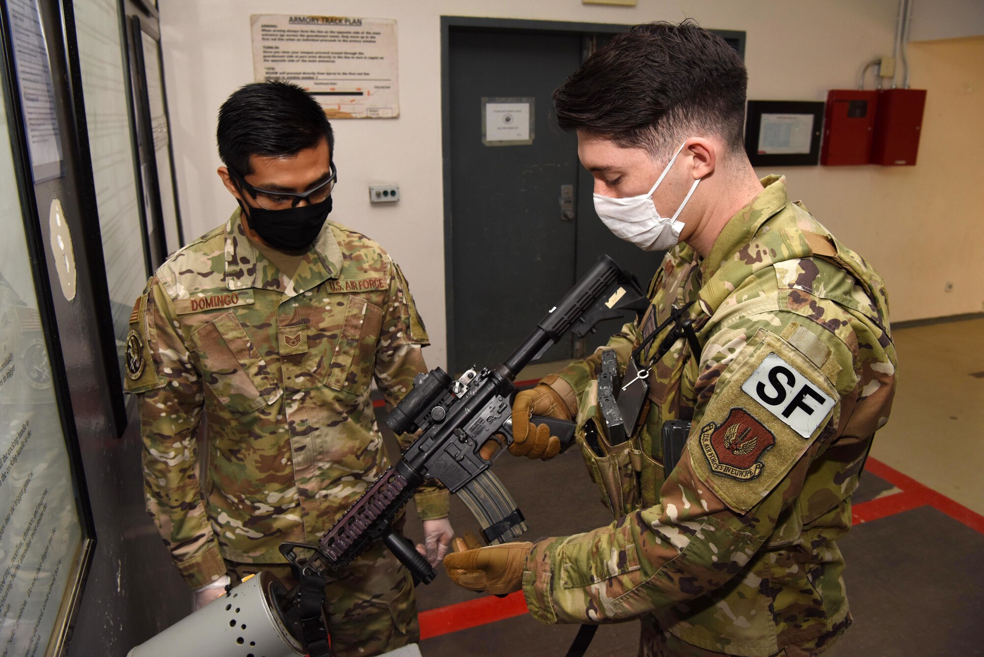 U.S. Air Force Staff Sgt. Jesse Domingo, 39th Security Forces Squadron Armory NCO in charge, arms Senior Airman Daniel Gutierrez, 39th SFS Security Response Team member, April 14, 2020, on Incirlik Air Base, Turkey. The Armory is in charge of arming and de-arming all members of the 39th SFS. (U.S. Air Force photo by Tech. Sgt. Jim Araos)