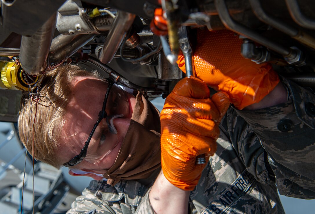 Airman 1st Class Ian Cernetich, 62nd Maintenance Squadron hydraulics apprentice, removes a hydraulic pump from the engine of a C-17 Globemaster III at Joint Base Lewis-McChord, Wash., April 14, 2020. The 62nd Airlift Wing has initiated a minimal manning posture and since maintenance Airmen are mission essential, they must take precautions such as wearing protective masks to stay healthy while working on aircraft. (U.S. Air Force photo by Senior Airman Tryphena Mayhugh)