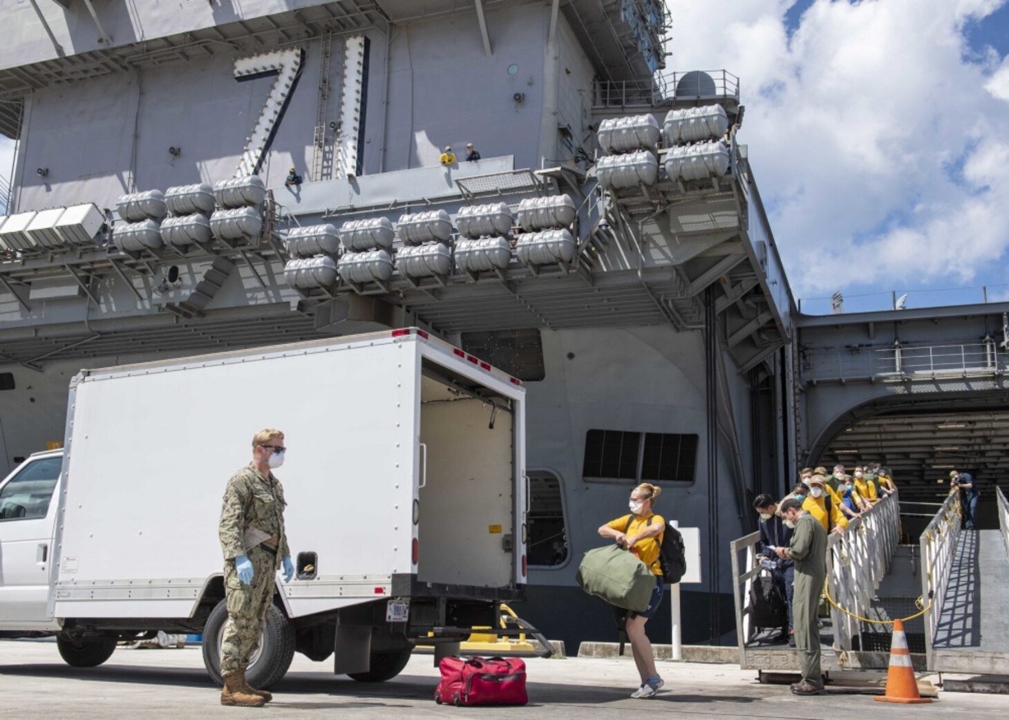 U.S. Sailors assigned to the aircraft carrier USS Theodore Roosevelt (CVN 71) depart the ship to move to off-ship berthing April 10, 2020. Upon arriving in Guam March 27, Theodore Roosevelt established an Emergency Command Center, initiated a roving and deep cleaning team, and continually educated the crew on social distancing and proper protective procedures and behaviors, to assist the crew in mitigating and controlling the spread of COVID. Theodore Roosevelt is in Guam for a scheduled port visit for resupply and crew rest during their scheduled deployment to the Indo-Pacific.