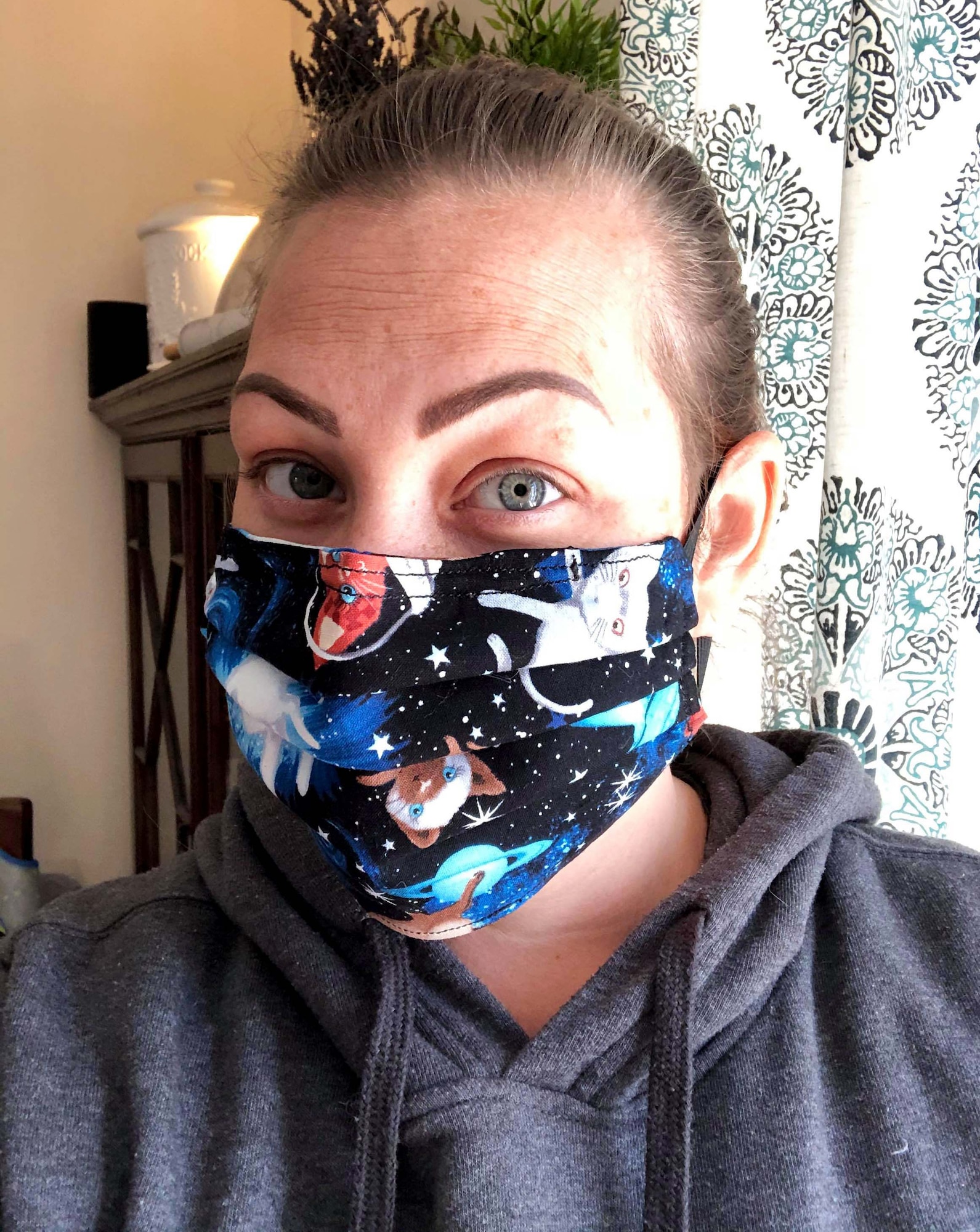 Katie Robertson, Mildenhall Spouses Association member, poses for a photo while wearing a protective mask she made at her home, April 15, 2020. The fabric used for each mask falls within guidelines of the Department of Defense color restrictions and mirrors the Centers for Disease Control’s instructions on how protective face masks should be made to protect individuals from COVID-19. (Courtesy photo)