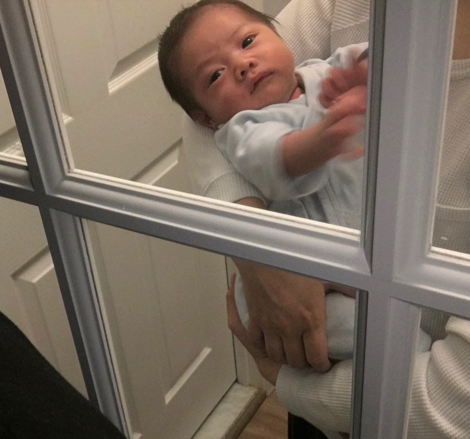 Sean Alejandro looks through a glass pane to his father, Master Sgt. Matthew Alejandro, 844th Communication Squadron executive team member, who was quarantined during Sean's birth. (U.S. Air Force photo/Master Sgt. Matthew Alejandro)