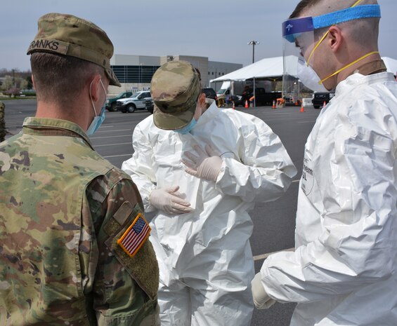 Several Soldiers from the Pennsylvania National Guard go through the procedures of sealing a suit during practice for COVID-19 testing at Mohegan Sun Arena in Wilkes-Barre, Pa., on April 19, 2020. The Pa. National Guard Soldiers are supporting the Department of Health’s operation to stand up a testing site to assist the community. (U.S. Army photo by Sgt. 1st Class Matthew Keeler)