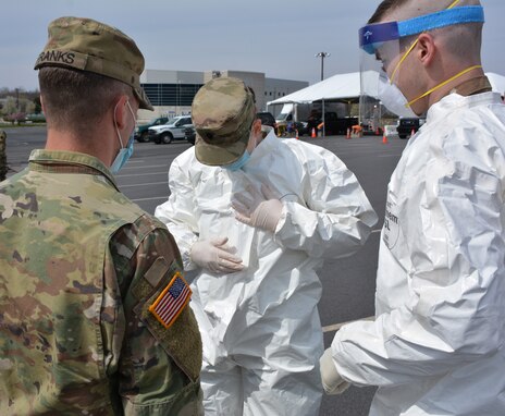 Several Soldiers from the Pennsylvania National Guard go through the procedures of sealing a suit during practice for COVID-19 testing at Mohegan Sun Arena in Wilkes-Barre, Pa., on April 19, 2020. The Pa. National Guard Soldiers are supporting the Department of Health’s operation to stand up a testing site to assist the community. (U.S. Army photo by Sgt. 1st Class Matthew Keeler)