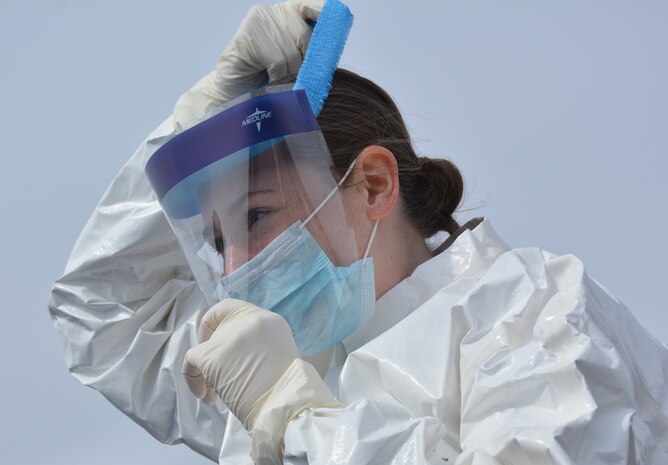 A Pennsylvania National Guard Soldier straps a shield over her face before the start of COVID-19 testing practice at Mohegan Sun Arena in Wilkes-Barre, Pa., on April 19, 2020. The practice consisted of walk-throughs of the operation of the lanes that would be run by teams from the Pa. National Guard, Pennsylvania Department of Health and Pennsylvania Emergency Management Agency  (U.S. Army photo by Sgt. 1st Class Matthew Keeler).