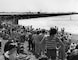 View of crowds on shore watching opening of Spillway in the background.