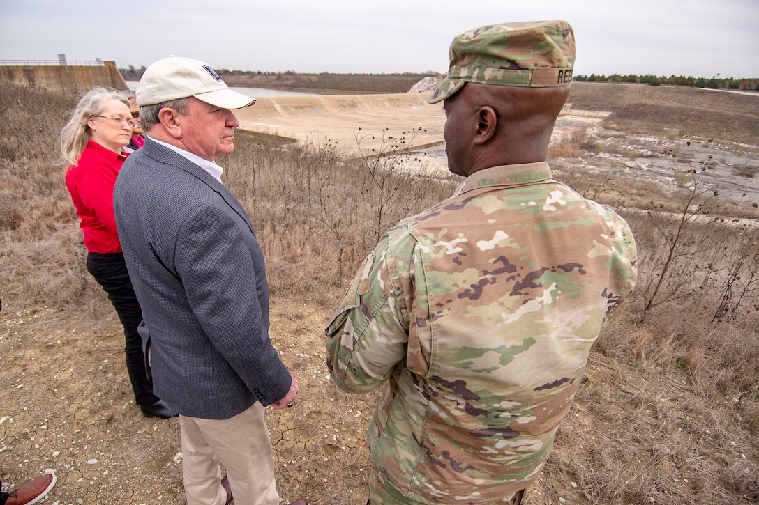 R.D. James, Assistant Secretary of the Army for Civil Works, middle, speaks with U.S. Army Corps of Engineers (USACE), Fort Worth District Commander Col. Kenneth Reed, right, and Dam Safety Project Manager Stacy Gray, left, during a visit to the Lewisville Dam Spillway. Mr. James visited Lewisville Lake to meet USACE Fort Worth staff and receive a brief of the Lewisville Dam Safety Modification and other lake projects. Fort Worth District was established in 1950. Lewisville Lake dam constructed in 1955, it has 187 miles of shoreline, 28 designated public use areas, 16,352 acres above normal pool and 5,747 acres of flowage easement. The district is responsible for water resources development in two-thirds of Texas, and design and construction at military installations in Texas and parts of Louisiana and New Mexico. U.S Army photo by Trevor Welsh.