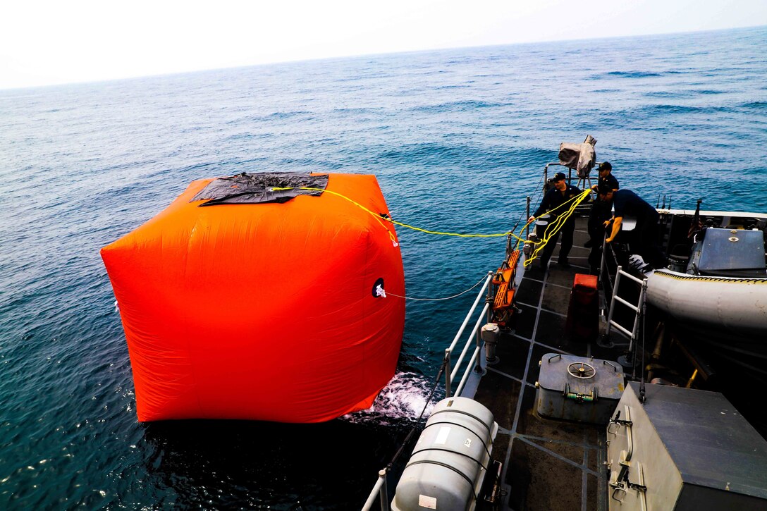 Sailors aboard the coastal patrol ship USS Sirocco (PC 6) place an inflatable target into the water during a live fire exercise with U.S. Army AH-64E Apache attack helicopter assigned to U.S. Army Central Command’s (USARCENT) Task Force Saber. Sirocco is deployed to the U.S. 5th Fleet area of operations in support of naval operations to ensure maritime stability and security in the central region, connecting the Mediterranean and the Pacific through the Western Indian Ocean and three strategic choke points.