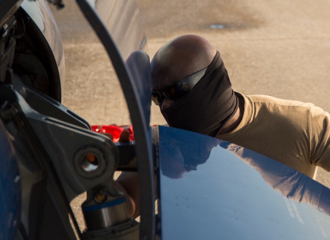 A crew chief wears additional personal protective equipment while inspecting a C-146A Wolfhound aircraft