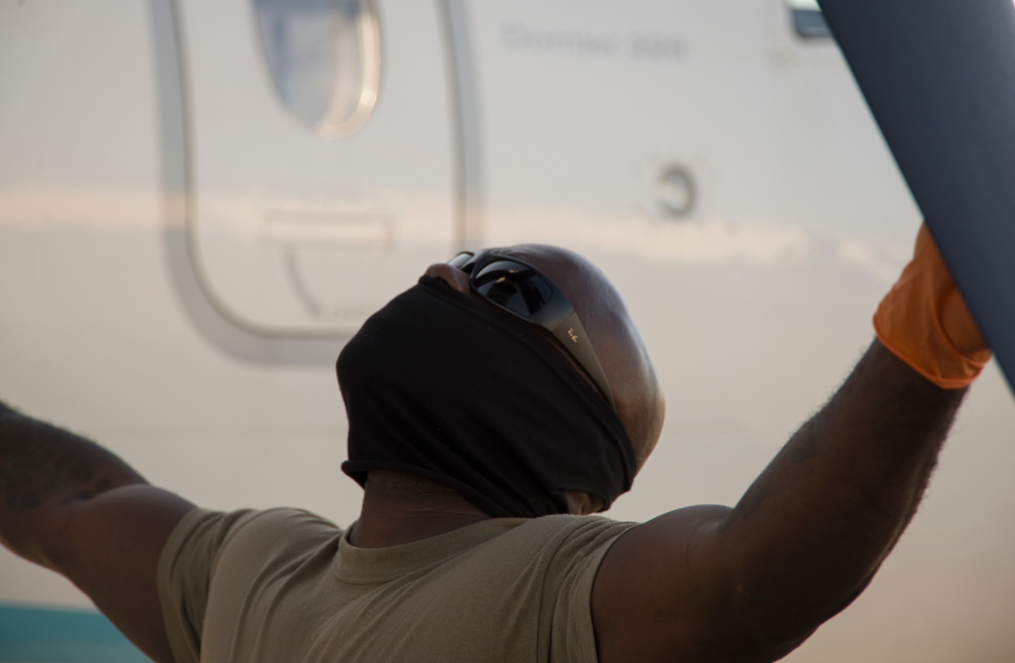 A crew chief wears additional personal protective equipment while inspecting a C-146A Wolfhound propeller