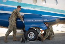 Crew chiefs inspect the wheels on a C-146A Wolfhound