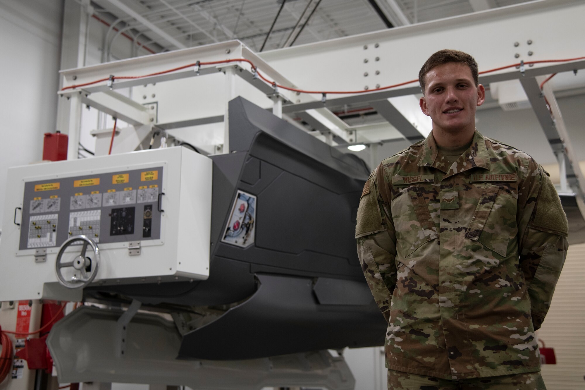 A1C Benjamin Missel poses with a landing gear trainer in the F-35 Academic Training Center, Eglin Air Force Base, Fla. on Mar. 12, 2020.