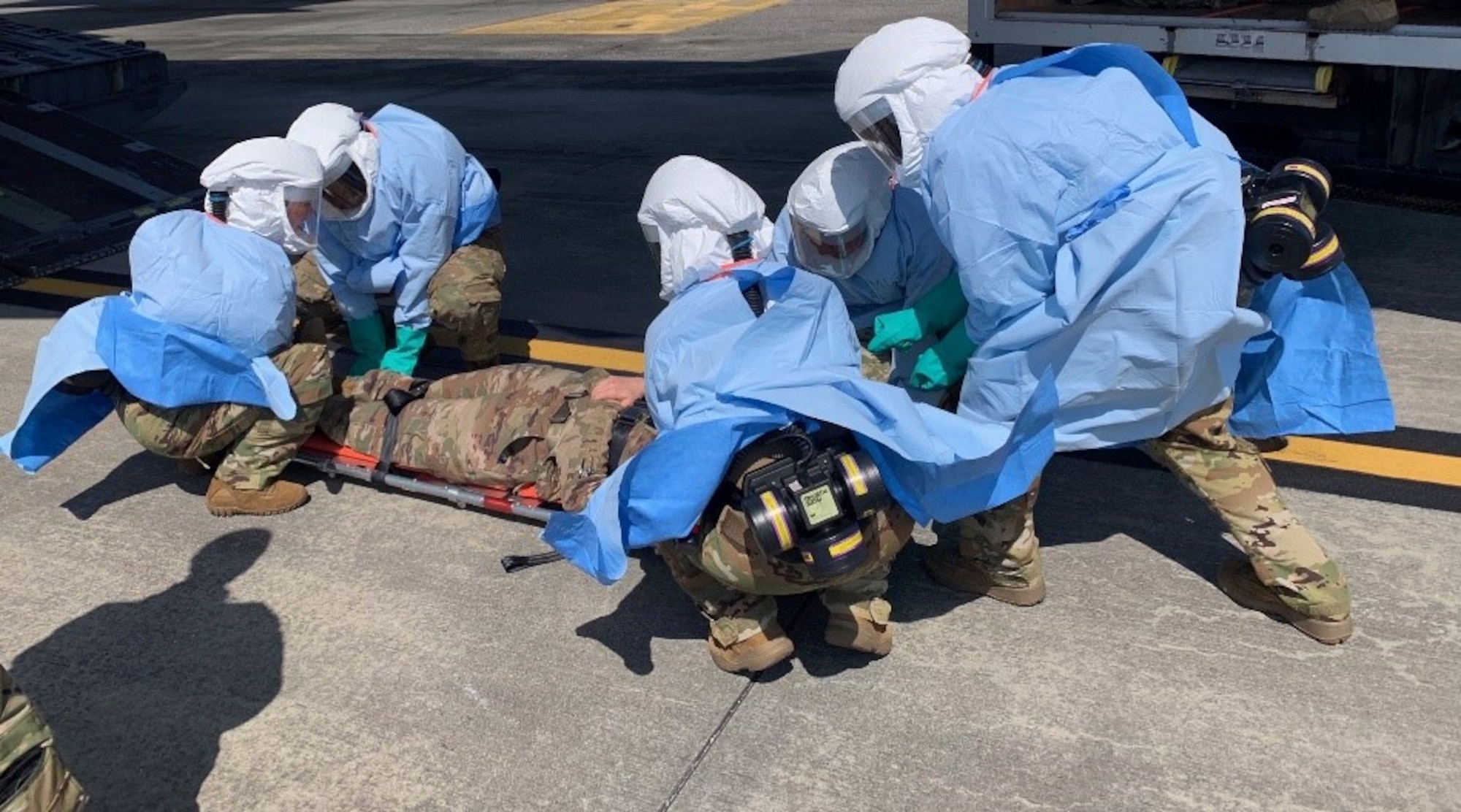 Members of the Portable Bio-Chemical Module test team prepare to load a patient.