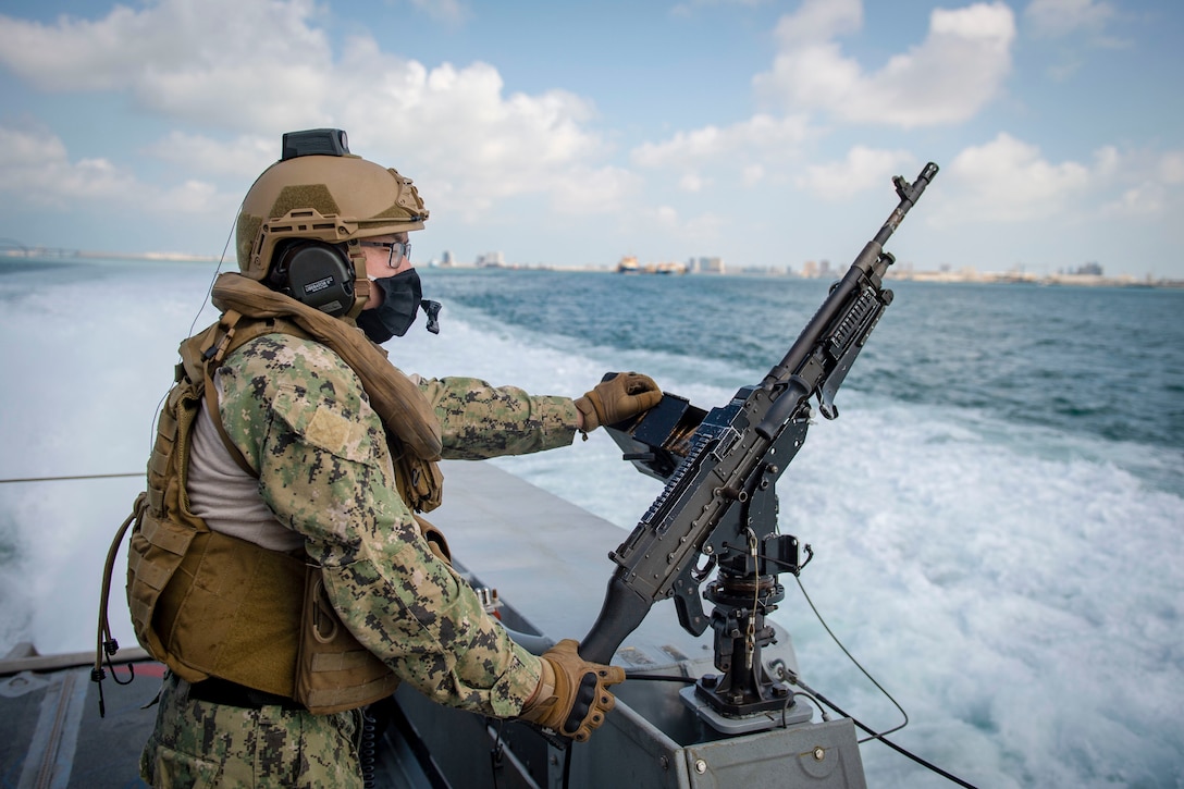 A sailor stands watch on a patrol boat.