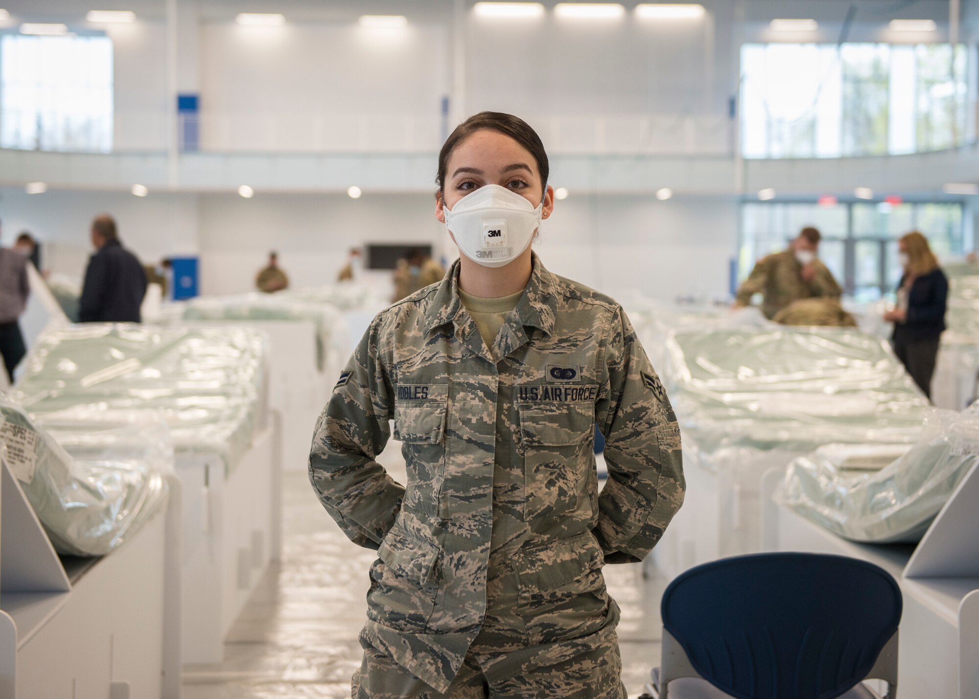 Airman 1st Class Arielle Robles, 103rd Maintenance Group administration specialist, helps set up recovery center beds at Kaiser Hall at Central Connecticut State University in New Britain, Connecticut, April 21, 2020. Robles is an exercise science student at the university and is now helping convert her usual classroom building into surge capacity space for local hospitals in response to the COVID-19 pandemic. (U.S. Air National Guard photo by Staff Sgt. Steven Tucker)