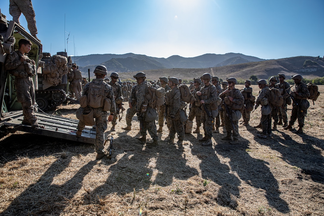 U.S. Marines with 2nd Battalion, 5th Marine Regiment, 1st Marine Division,  prepare to enter an assault amphibious vehicle during a Marine Corps Combat Readiness Evaluation (MCCRE) on Marine Corps Base Camp Pendleton, California, Sept. 23, 2019. 5th Marines conducted a regimental-sized MCCRE for 1st Battalion, 5th Marines and 2nd Battalion, 5th Marines, as well as the Regimental Headquarters to increase the combat proficiency and readiness of the regiment. The MCCRE took place over a 10 day period and served as proof of concept for future regimental-sized MCCREs. (U.S. Marine Corps photo by Lance Cpl. Roxanna Ortiz)